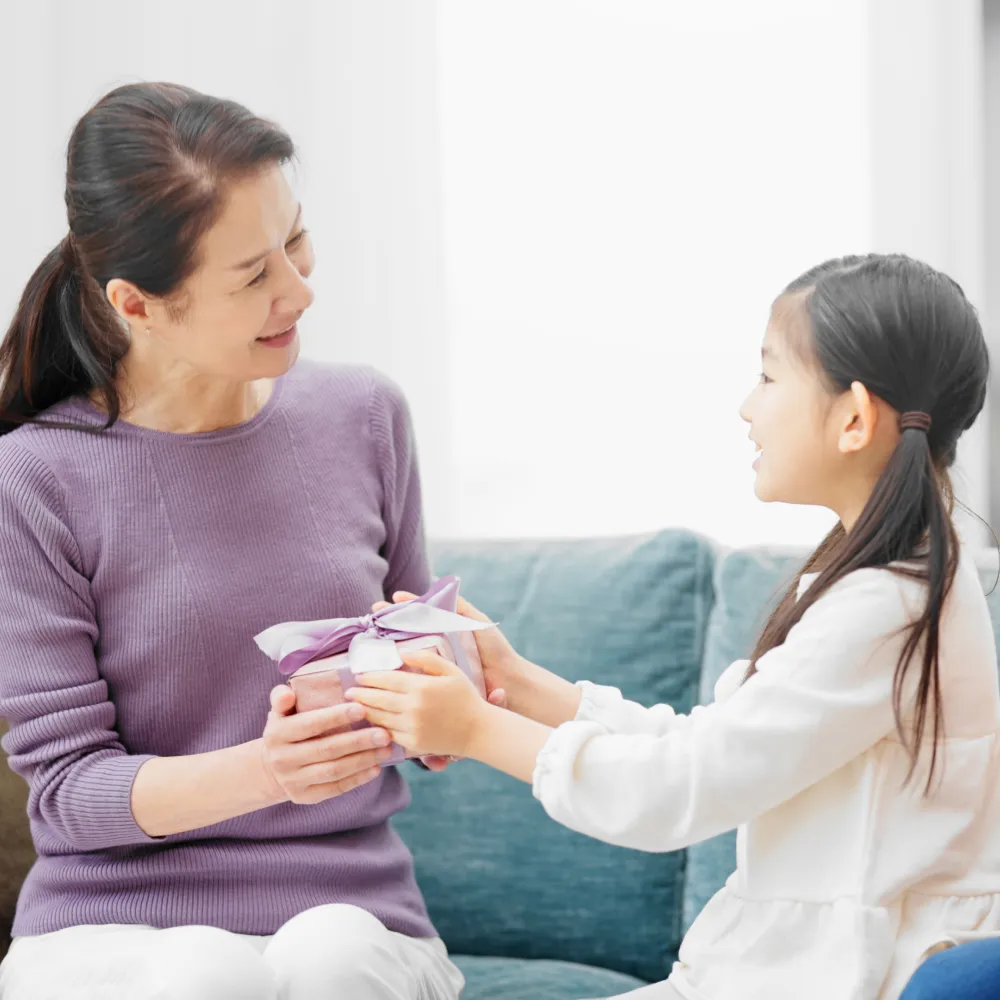 祖父母と孫が笑顔で会話している家族団らんの様子